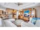 Open living room featuring hardwood floors, a ceiling fan, a large entertainment center, and a white sectional sofa at 2625 Yuma Ave, North Port, FL 34286