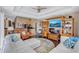 Open living room featuring a large white sectional, ceiling fan, and views to kitchen at 2625 Yuma Ave, North Port, FL 34286