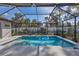 An in-ground pool is surrounded by a screen enclosure and backyard landscaping at 2625 Yuma Ave, North Port, FL 34286