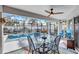 A screened in lanai features a dining table, a ceiling fan and offers a view of the pool at 2625 Yuma Ave, North Port, FL 34286
