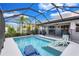 Inviting screened-in pool with a sun shelf and surrounded by tropical landscaping at 2625 Yuma Ave, North Port, FL 34286