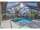 A swimming pool with a screen enclosure is surrounded by backyard landscaping at 2625 Yuma Ave, North Port, FL 34286