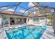 Backyard in-ground pool with patio, screened in lanai, and lawn chair at 2625 Yuma Ave, North Port, FL 34286