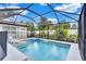 Screened-in pool with a sun shelf, tropical landscaping, and comfortable lounge chairs at 2625 Yuma Ave, North Port, FL 34286