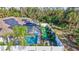 Aerial view of a screened-in pool, solar panels, and fenced yard with ' play area at 2625 Yuma Ave, North Port, FL 34286