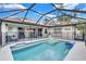A beautiful screened-in pool area surrounded by lush landscaping and offering a relaxing retreat at 2625 Yuma Ave, North Port, FL 34286