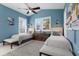 Comfortable bedroom featuring two twin beds, overhead fan, and natural light from the window at 2828 Riverview Blvd, Bradenton, FL 34205