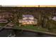Elegant waterfront home with lush landscaping, a private dock, and manicured lawn illuminated at twilight at 2828 Riverview Blvd, Bradenton, FL 34205