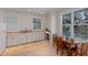 Bright kitchenette featuring white cabinetry, natural stone countertops, and wood table set at 2828 Riverview Blvd, Bradenton, FL 34205