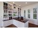Well-lit home office featuring custom built-in bookshelves and a cherry desktop at 2828 Riverview Blvd, Bradenton, FL 34205