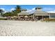 Beachfront restaurant featuring outdoor seating under umbrellas on white sand at 2828 Riverview Blvd, Bradenton, FL 34205