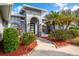 Charming home exterior featuring lush tropical landscaping, an arched entryway, and a freshly painted facade at 292 Long Meadow Ln, Rotonda West, FL 33947