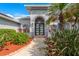 The entrance to the home with a walkway, lush greenery, and a contemporary door design at 292 Long Meadow Ln, Rotonda West, FL 33947