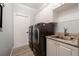Modern laundry room with granite countertop, sink, and stainless steel washer and dryer at 292 Long Meadow Ln, Rotonda West, FL 33947