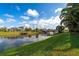 Scenic waterfront view of a canal, a dock, and lush green landscaping under a blue sky at 292 Long Meadow Ln, Rotonda West, FL 33947
