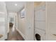 Hallway laundry closet features stacked washer and dryer behind white louvered doors at 3330 Thornwood Rd # 3330, Sarasota, FL 34231