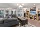 Bright living room featuring a gray sectional sofa, modern lighting, and large glass doors to the outside at 3330 Thornwood Rd # 3330, Sarasota, FL 34231