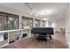 Bright living room with hardwood floors, large windows, and a sleek black grand piano at 3330 Thornwood Rd # 3330, Sarasota, FL 34231