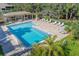 Aerial view of large pool area with tables, chairs, and lounge seating under pergolas at 3330 Thornwood Rd # 3330, Sarasota, FL 34231