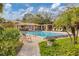 Community pool with lounge chairs, pergola covered seating area and lush landscaping at 3330 Thornwood Rd # 3330, Sarasota, FL 34231
