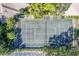 Aerial view of fenced tennis court surrounded by lush, mature trees, close to parking at 3330 Thornwood Rd # 3330, Sarasota, FL 34231