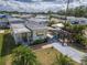Aerial view of this property showcasing tropical palm trees, a long driveway, and a covered patio with colorful umbrellas at 4103 12Th Street E Ct, Ellenton, FL 34222