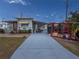 Charming home featuring a long driveway leading up to a red-doored home with colorful flowers and a trellis covered patio at 4103 12Th Street E Ct, Ellenton, FL 34222
