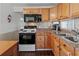 Cozy kitchen featuring wood cabinets, a black microwave, and a double-basin sink at 4103 12Th Street E Ct, Ellenton, FL 34222