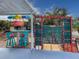 Outdoor patio has a dining space under a colorful umbrella, surrounded by lush landscaping at 4103 12Th Street E Ct, Ellenton, FL 34222