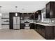 Bright kitchen with dark wood cabinets, stainless steel appliances, and contemporary backsplash at 4104 35Th W Ave, Bradenton, FL 34205