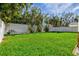 Lush green backyard with a white fence line and various shade trees at 4117 Roberts Point Cir, Sarasota, FL 34242