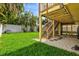 View of lush backyard and undercarriage to deck with stairs at 4117 Roberts Point Cir, Sarasota, FL 34242