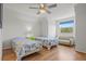Bright bedroom features two twin beds, ceiling fan, hardwood floors and a comfortable seating area at 4117 Roberts Point Cir, Sarasota, FL 34242