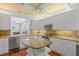 Bright kitchen features custom cabinets, granite countertops, stainless steel appliances, and island at 4117 Roberts Point Cir, Sarasota, FL 34242