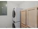 Laundry area with stackable washer and dryer unit and wooden cabinets at 4117 Roberts Point Cir, Sarasota, FL 34242