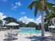 Community pool featuring palm trees, a mural, patio umbrellas, and poolside furniture at 415 Oakwood E Blvd, Sarasota, FL 34237