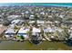 Aerial view of waterfront home with private pool and dock surrounded by lush tropical landscaping at 5073 Higel Ave, Sarasota, FL 34242