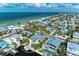 Aerial view of a stunning coastal home with pool, boat dock, and beautiful water views at 526 Loquat Dr, Anna Maria, FL 34216