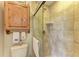Bathroom featuring tiled shower with glass door and classic fixtures plus toilet and decor at 526 Loquat Dr, Anna Maria, FL 34216