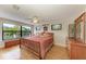 Bright bedroom with wood floors, large windows offering green views, and classic wood furniture at 526 Loquat Dr, Anna Maria, FL 34216