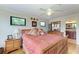 Bright bedroom featuring hardwood floors, neutral walls, windows, and a view into the ensuite bathroom at 526 Loquat Dr, Anna Maria, FL 34216