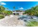 Beautiful home exterior with well-manicured landscaping, an inviting pool, and a paved driveway at 526 Loquat Dr, Anna Maria, FL 34216