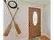 Inviting front entrance with wood door featuring decorative glass, paired with coastal themed oars at 526 Loquat Dr, Anna Maria, FL 34216