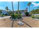 Charming front yard featuring lush landscaping, decorative rocks, and flowering plants, adding curb appeal at 526 Loquat Dr, Anna Maria, FL 34216