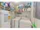 Functional laundry room with washer, dryer, water heater, and storage shelves at 526 Loquat Dr, Anna Maria, FL 34216