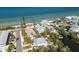 Scenic aerial view of coastal homes nestled along the shoreline, complemented by clear blue waters and a boat-friendly canal at 527 Magnolia Ave, Anna Maria, FL 34216