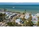 Aerial perspective of a charming beachside community with lush greenery and tranquil shoreline and bayou views at 527 Magnolia Ave, Anna Maria, FL 34216