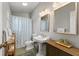 Bathroom with a pedestal sink, patterned shower curtain, and vintage charm at 527 Magnolia Ave, Anna Maria, FL 34216