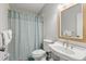 Traditional bathroom featuring a white sink and toilet alongside a blue patterned shower curtain at 527 Magnolia Ave, Anna Maria, FL 34216