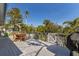 Outdoor deck with a wooden dining table, a grill, and a tranquil outdoor seating arrangement at 527 Magnolia Ave, Anna Maria, FL 34216